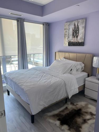 a bedroom with a king sized bed with purple walls at Downtown Luxury Condo Gym & Parking in Toronto