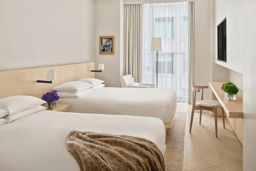 a hotel room with two beds and a desk at The Times Square EDITION New York in New York