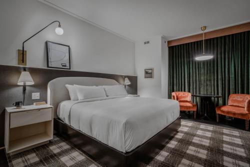 ein Schlafzimmer mit einem großen Bett und einem Stuhl in der Unterkunft Hotel Longmont in Longmont