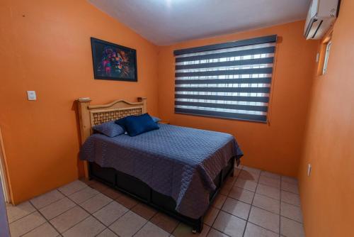 a bedroom with a bed and a window at Cómoda Casa a 7 minutos de la playa in Ciudad Madero