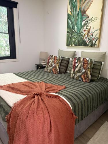 a bed with an orange blanket and pillows on it at Sunset Ridge - King Bed Cabin & Breakfast Basket in Boyland