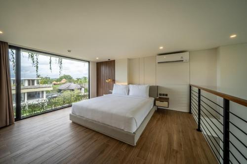 a bedroom with a large bed and a large window at Horizon Apartment with Ocean View in Cemagi