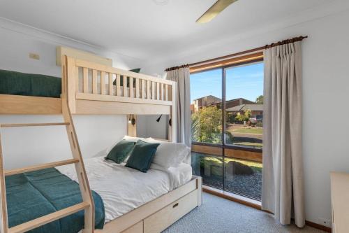 a bedroom with a bunk bed and a large window at Glassy Waters in Sussex Inlet