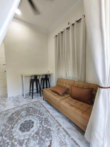 a living room with a couch and a table at Asyhani Cottage in Bachok