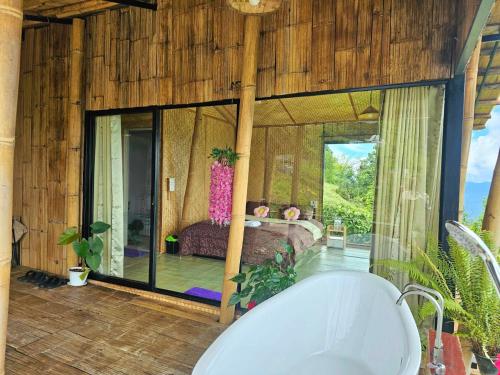 a bathroom with a bath tub and a bedroom at Mon Ngo misty haven B3 in Ban Nong Chaeng