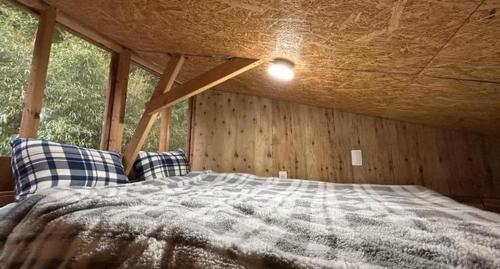 a bed in a room with a wooden wall at NAT PARK Isumi RV in Iwada
