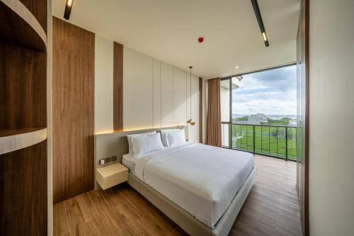 a bedroom with a white bed and a large window at Horizon Cemagi 2BR with Ocean View in Cemagi