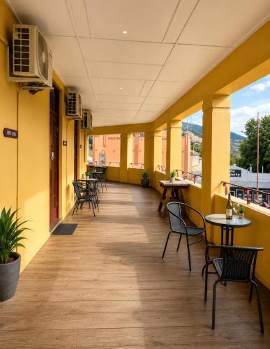 a room with tables and chairs and yellow walls at Golden Age Hotel in Omeo