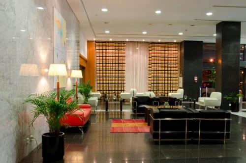 a lobby with couches and chairs in a building at VIP Executive Santa Iria Hotel in Santa Iria da Azóia