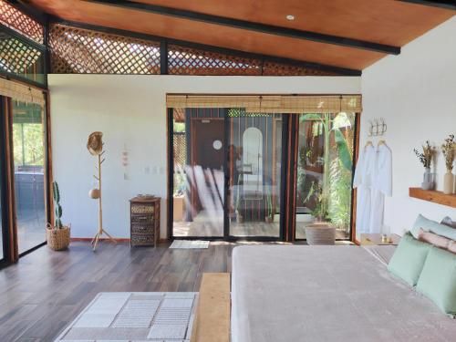 a living room with a bed and sliding glass doors at Cocolhu Treehouse & Ocean View in Tamarindo