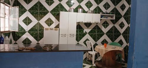 a kitchen with a green and white tiled wall at Lazer do DUELÃO in Pão de Açúcar
