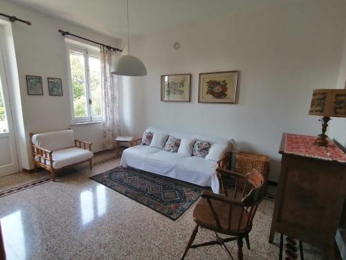 a living room with a white couch and a chair at La Casina a Oleggio in Oleggio