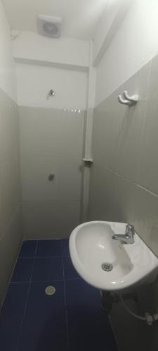 a bathroom with a white sink and a blue floor at Casa Hotel La Unión in Santa Cruz de Mompox