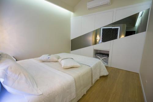 a white bedroom with a bed with two pillows on it at Hotel Estalagem Turismo in Bragança