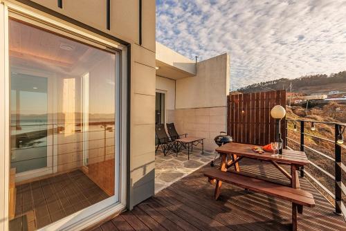 a balcony with a wooden bench and a table at M129 Pension Namhae in Namhae