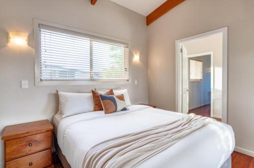 a bedroom with a white bed and a window at Maleny Terrace Cottages in Maleny