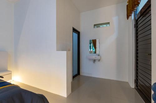 a bedroom with a sink and a mirror on the wall at Barusen Hills By BHATARA in Gambung