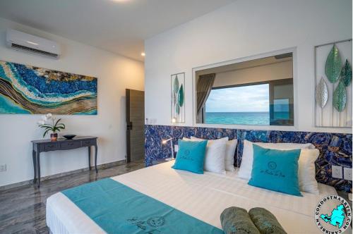 a bedroom with a large bed with blue pillows at condostmaarten by the sea -Adults Only- in Koolbaai