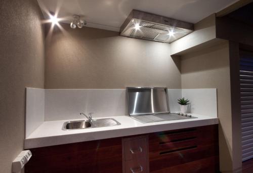 a kitchen counter with a sink in a room at Amaroo by the beach in Queenscliff