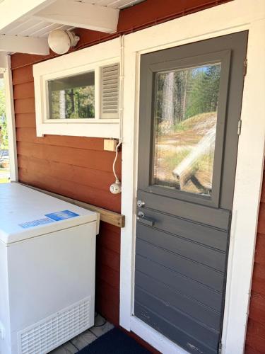 eine Tür zu einem winzigen Haus mit einer Waschmaschine in der Unterkunft Verstas in Kustavi