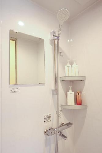 a white bathroom with a shower and a mirror at DON chan GuestHouse Nikko ,7 minutes walk from Imaichi Station in Nikko
