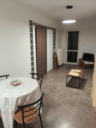 a living room with a table and chairs and a room with a table at Parishouse by zarkco in Porto Rafti