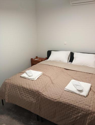 a bed with two towels on top of it at Parishouse by zarkco in Porto Rafti