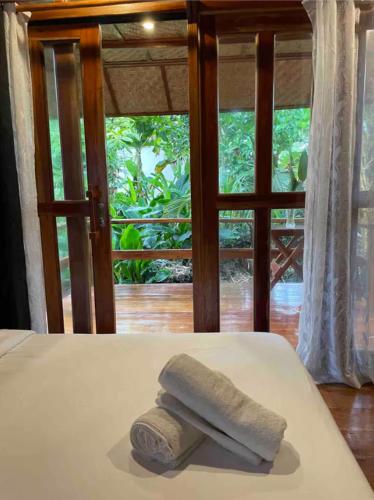 a towel sitting on a bed in front of a window at Baha Bar in San Juan