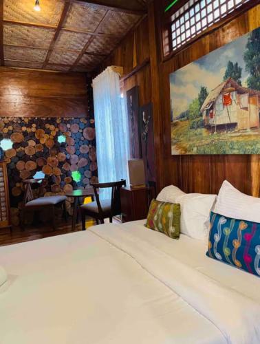 a bedroom with a bed and a table and a painting at Baha Bar in San Juan