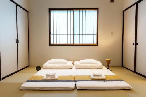 three beds in a room with a window at Irodori Hotel AKANE in Fukuoka