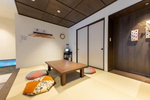 a room with a table and pillows on the floor at Irodori Hotel AKANE in Fukuoka