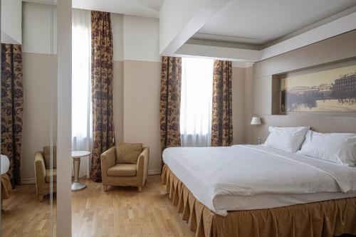 a hotel room with a bed and a chair at Opera Hotel in Riga