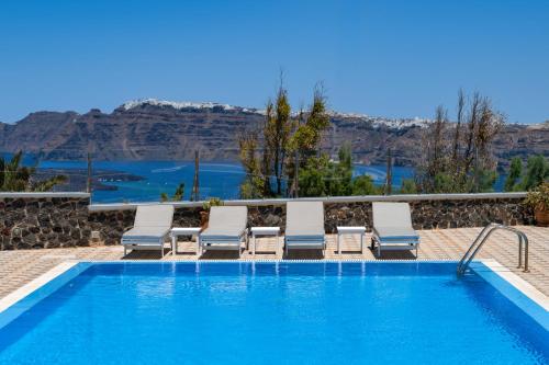 a swimming pool with chaise lounge chairs and a swimming pool at Sigal Villa in Akrotiri