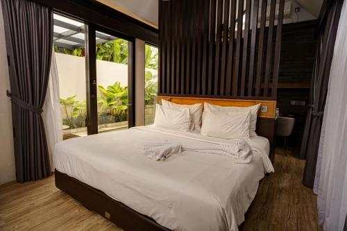 a bedroom with a large bed with white sheets and pillows at Sunsetfalls Gardens and Resort in Magelang