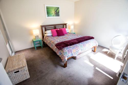 a bedroom with a bed with pink pillows at Bella Casa in Queenscliff