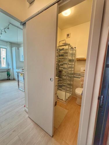 a bathroom with a toilet and a glass door at HOME PERLa in San Bartolomeo al Mare