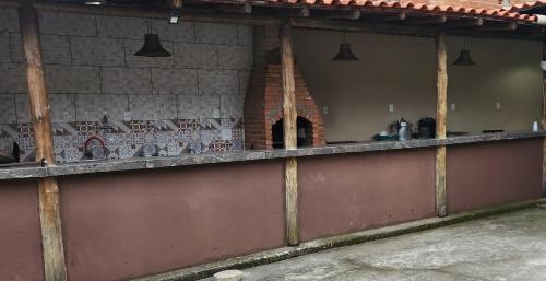 a kitchen with a counter and a brick oven at Chalé Selá - Recanto 23 - Espaço Inteiro - Entre Angra e Paraty in Angra dos Reis