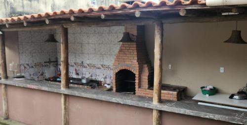 a kitchen with a brick oven on a wall at Chalé Selá - Recanto 23 - Espaço Inteiro - Entre Angra e Paraty in Angra dos Reis