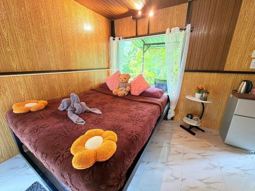 a bedroom with a bed with two stuffed animals on it at Amornkeeree Khao Sok Camping in Khao Sok National Park