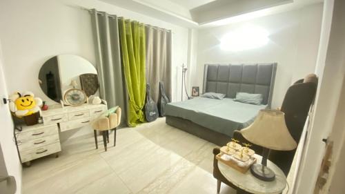 a bedroom with a bed and a mirror and a table at Dimond Villa in Greater Noida