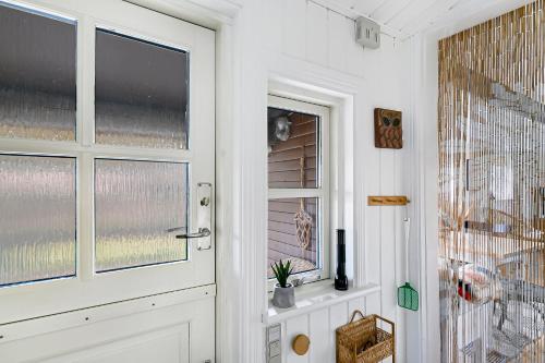 a white door with a window in a room at Cozy Holiday Home Close To Forest And Beach in Hasle