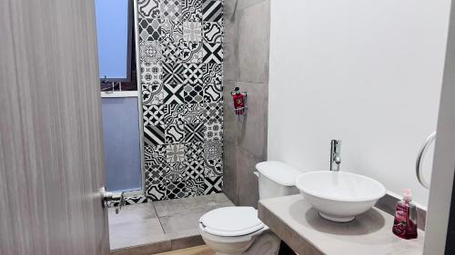 a bathroom with a white toilet and a sink at Torre 23 in Oaxaca City