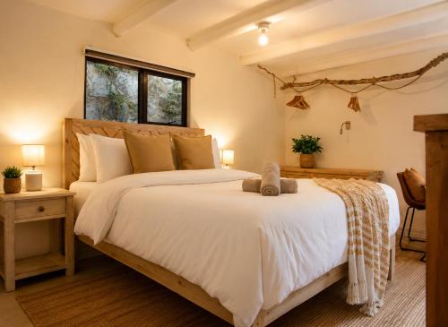 a bedroom with a large white bed and a window at Kaaimans River Villa in Wilderness