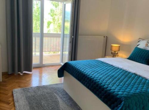 a bedroom with a bed with a blue blanket on it at Apartman Ivanka in Imotski