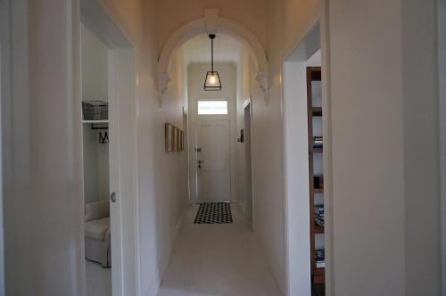 a hallway with a hallway leading to a white door at Chevignon in Queenscliff