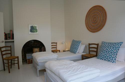 a living room with two white couches and a fireplace at Chevignon in Queenscliff