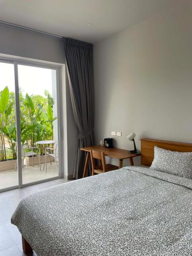 a bedroom with a bed and a sliding glass door at Hidden Bay Chaloklam in Chaloklum