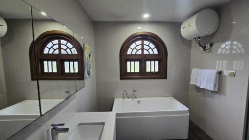 a bathroom with a tub and a sink and a mirror at Golden Ridge Sigiriya in Dambulla