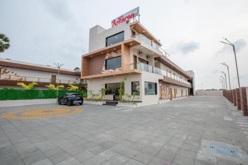 a building with a car parked in a parking lot at La Antaraa in Arumuganeri