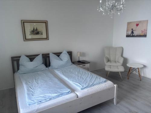a bedroom with a bed and a chair and a chandelier at Haus 4 you in Winden am See